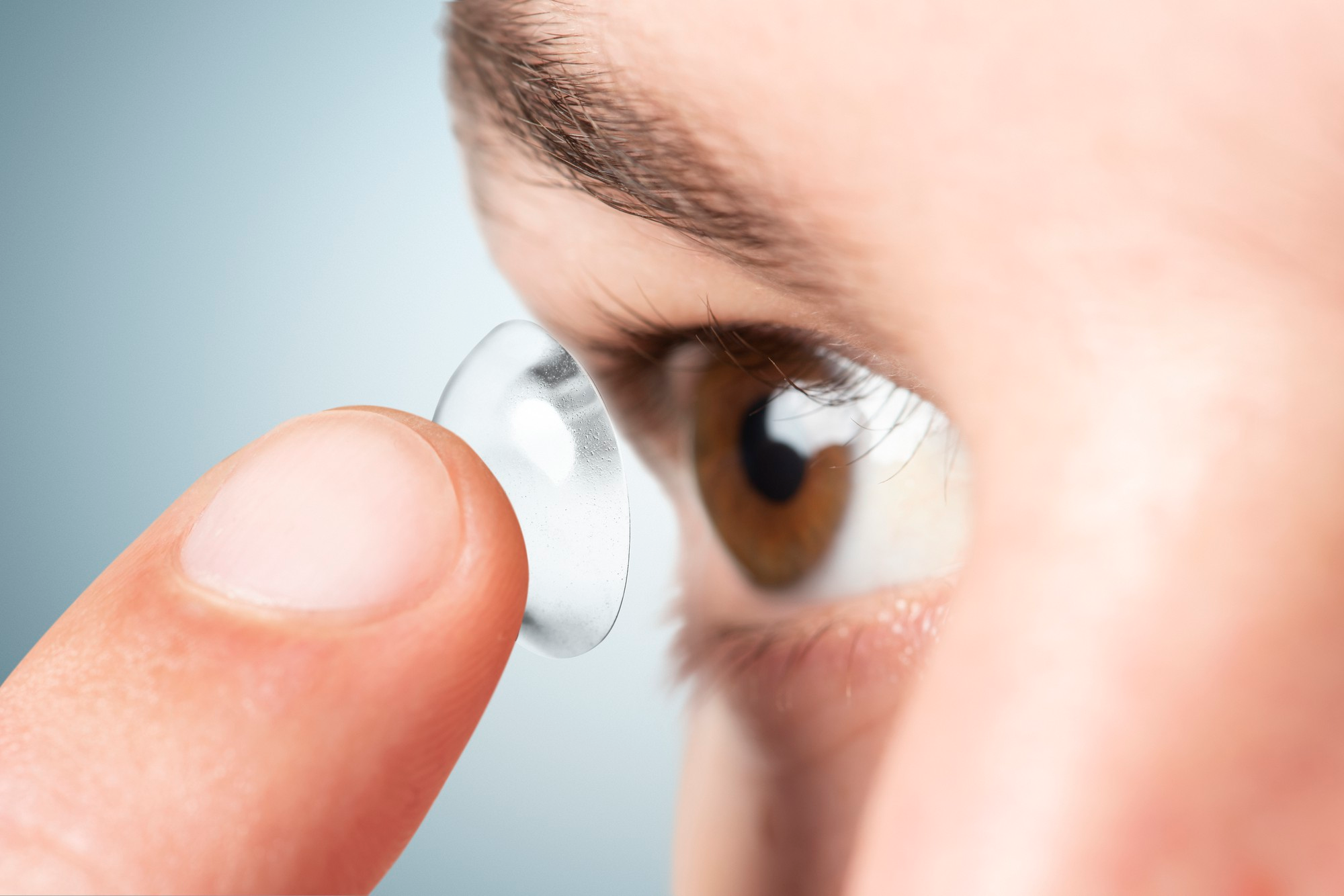 Person preparing to insert a contact lens